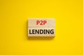 P2P peer to peer lending symbol. Concept words P2P lending on wooden blocks on a beautiful yellow background. Business and P2P