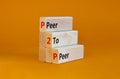 P2P, peer to peer symbol. Wooden blocks with concept words `P2P, peer to peer`. Beautiful orange background, copy space. Busines