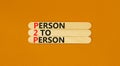 P2P person to person symbol. Concept words P2P person to person on wooden stick on a beautiful orange table orange background.