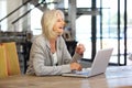 Happy older business woman working on laptop