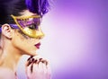 Paarty woman swearing golden mask on light backgound Royalty Free Stock Photo