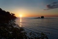 Pacific coast of Costa Rica in Central America, evening sunset with palm trees, ocean and clouds on the red sky Royalty Free Stock Photo