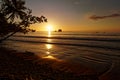 Pacific coast of Costa Rica in Central America, evening sunset with palm trees, ocean and clouds on the red sky Royalty Free Stock Photo