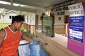 Pacific Island man fill up fresh water from a water station in A