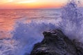 Pacific Ocean waves crashing on rocks at Baker Beach by Golden Gate Bridge at colorful sunset in San Francisco Royalty Free Stock Photo