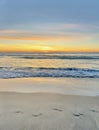 Pacific Serenity: Sunset, Tranquil Waves, and Solitary Footprints