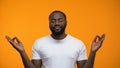 Pacified black man meditating against yellow background, breathing exercises