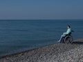 Pacified caucasian woman in a wheelchair on the seashore.