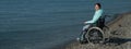 Pacified caucasian woman in a wheelchair on the seashore.