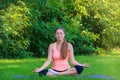 Pacified woman in a pink top doing yoga in the morning