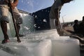 Ice block Worker splitting ice before moving the ice from truck to fishing boat Royalty Free Stock Photo