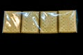 A pack of cookies or crackers in cellophane packaging on a black background Royalty Free Stock Photo