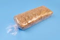 Pack of hay for guinea pigs in plastic bag in blue table. Bedding hay for rabbit. Front view, mockup