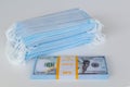 A pack of medical masks and a stack of 100 dollars bills as a symbol of higher prices and a deficiency in the protection of the