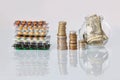 Pack of medicine pills with three packs of coins and glass bottle with dollar cash money