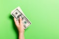 Pack of one hundred dollar bills in femle hands with copy space. Top view of money saving concept on colorful background