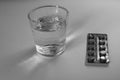 Pack of pills and glass of water. Black and White