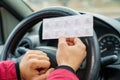 Pack of pills in the hands of the driver on a blurred background of the steering wheel in the car