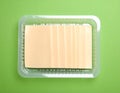 Pack of sliced, Cheese on green background, top view Royalty Free Stock Photo