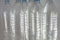 Pack of standing Bottles of a liter and a half of empty mineral water without caps just with the sealing ring on a white