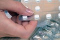 Pack of tablets held in one hand in front of other packagings