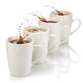 Pack of white mugs with coffee splash isolated on white background Royalty Free Stock Photo