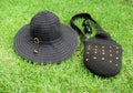 Packable black wide-brim sun hat, crochet bag and sunglasses on green grass Royalty Free Stock Photo