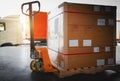 Package Boxes Wrapped Plastic Stacked on Pallets. Hand Pallet Truck. Forklift Loader. Warehouse Logistics Cargo Transport Royalty Free Stock Photo