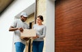 Package Delivery. Man Courier Delivering Box To Woman At Home Royalty Free Stock Photo