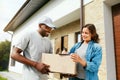 Package Delivery. Man Courier Delivering Box To Woman At Home Royalty Free Stock Photo