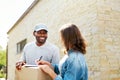 Package Delivery. Man Courier Delivering Box To Woman At Home Royalty Free Stock Photo