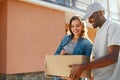 Package Delivery. Man Courier Delivering Box To Woman At Home Royalty Free Stock Photo