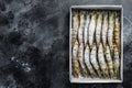 Package of frozen tiger prawns, shrimps. Black background. Top view. Copy space