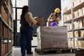 Package handler bringing parcels to warehouse worker for packing Royalty Free Stock Photo