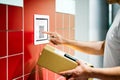 Package locker machine. Parcel service. Box and mobile phone. Man using code to collect delivery. Royalty Free Stock Photo