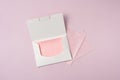 Package of rose Facial Cleanser Oil Control Absorbing Sheets on pink isolated background. Protable Face Oil Blotting Paper