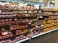 Packaged bread section in supermarket. Long aisle loaves of bread for sale in grocery store