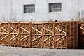 Packaged firewood on wooden pallets prepared for selling in factory backyard