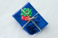 A Packaged gift with Christmas symbols, white snow background. Royalty Free Stock Photo