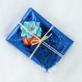 Packaged gift with Christmas symbols, white snow background Royalty Free Stock Photo