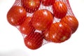 Packaged tomatoes hanging in red plastic net Royalty Free Stock Photo