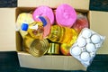 Packaged up different foodstuffs in donation box for poor. Canned food, oil, eggs, fruits, pasta. Top view, flat lay. Close-up Royalty Free Stock Photo