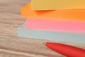 Packages of colorful stickers for notes and a pen on a wooden table Royalty Free Stock Photo