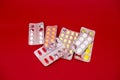 packages of different tablets and capsules on a red background Royalty Free Stock Photo