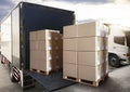 Packaging Boxes Stack on Pallets Loading into Cargo Container. Shipping Trucks. Supply Chain Shipment Boxes. Distribution Supplies