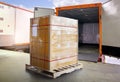 Packaging Boxes Wrapped Plastic on Pallets Loading into Shipping Cargo Container. Delivery Trucks Parked Loading at Dock Warehouse Royalty Free Stock Photo