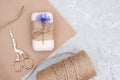 Packaging of natural handmade soap, decorated kraft paper , blue flower, skein of twine and scissors. Concept of organic cosmetics