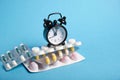 Packaging of tablets and pills on the table with clock in the middle. Medicine Royalty Free Stock Photo