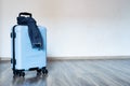 Packed blue travel bag on wheels with scarf around handle. Royalty Free Stock Photo