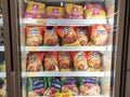 Packed chicken nugget in various brand placed in display chiller refrigerator inside the huge supermarket.